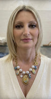 Collana a catena dorata con perle e ciondoli.
